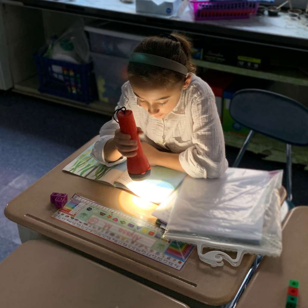 student reading with flashlight