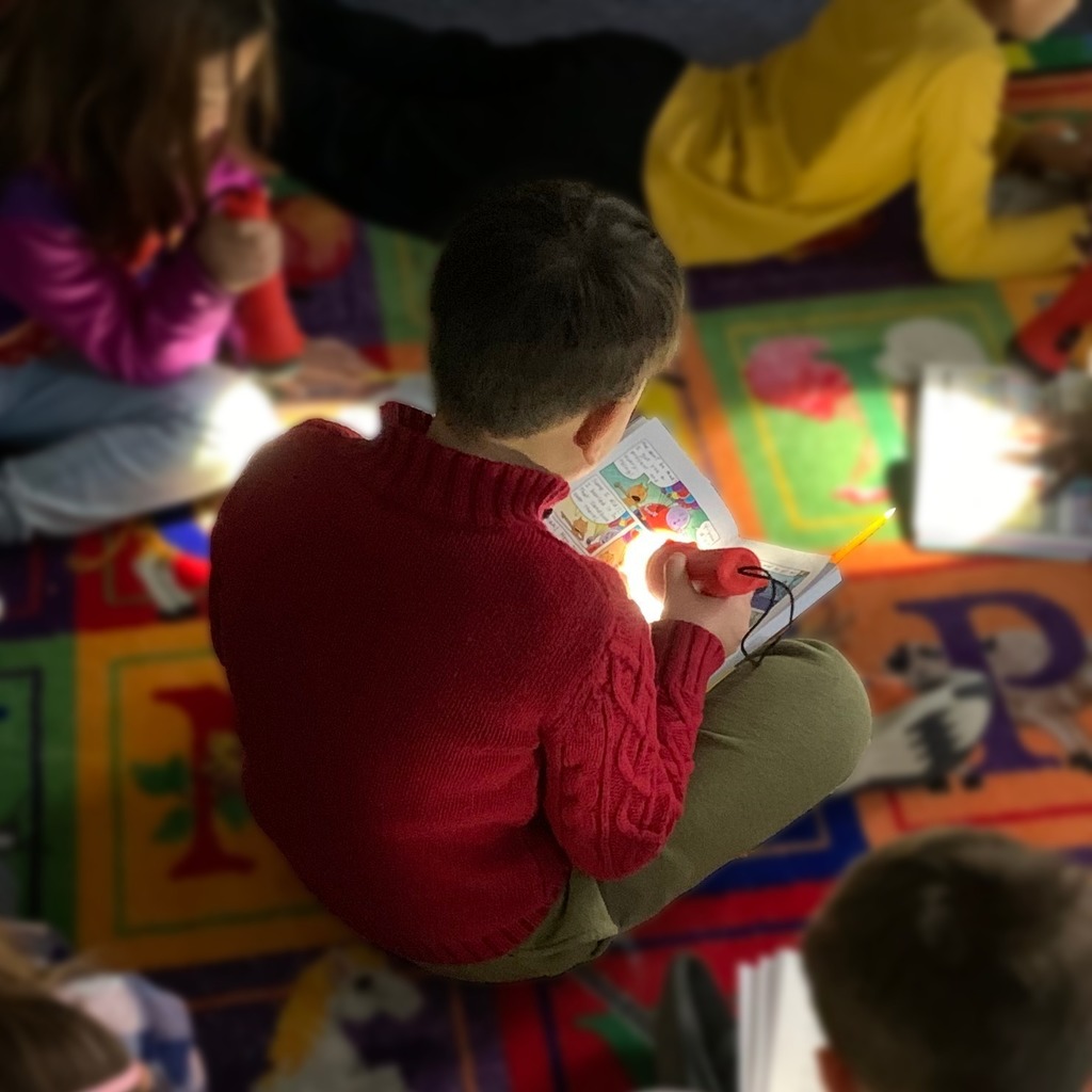 student reading with flashlight